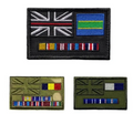 Three embroidered military-style patches shown on a plain white background: one large black patch at the top with a Union Jack with a red stripe, a blue-and-green panel, and multiple service ribbons; two smaller olive green patches below, one with a Union Jack, a yellow/red/blue flag, and ribbons, and one with a Union Jack, a blue/white flag, and ribbons.